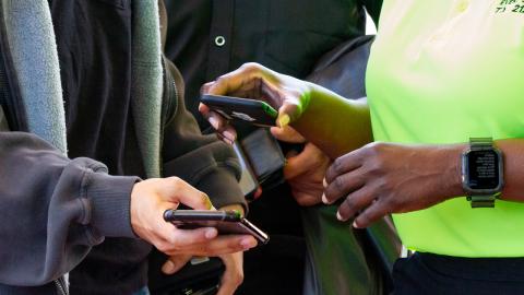 A guard scans a guest's ticket on their phone.